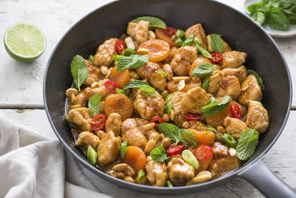 Bocconcini di pollo alla birra bionda in padella con albicocche, arachidi, peperoncino e menta