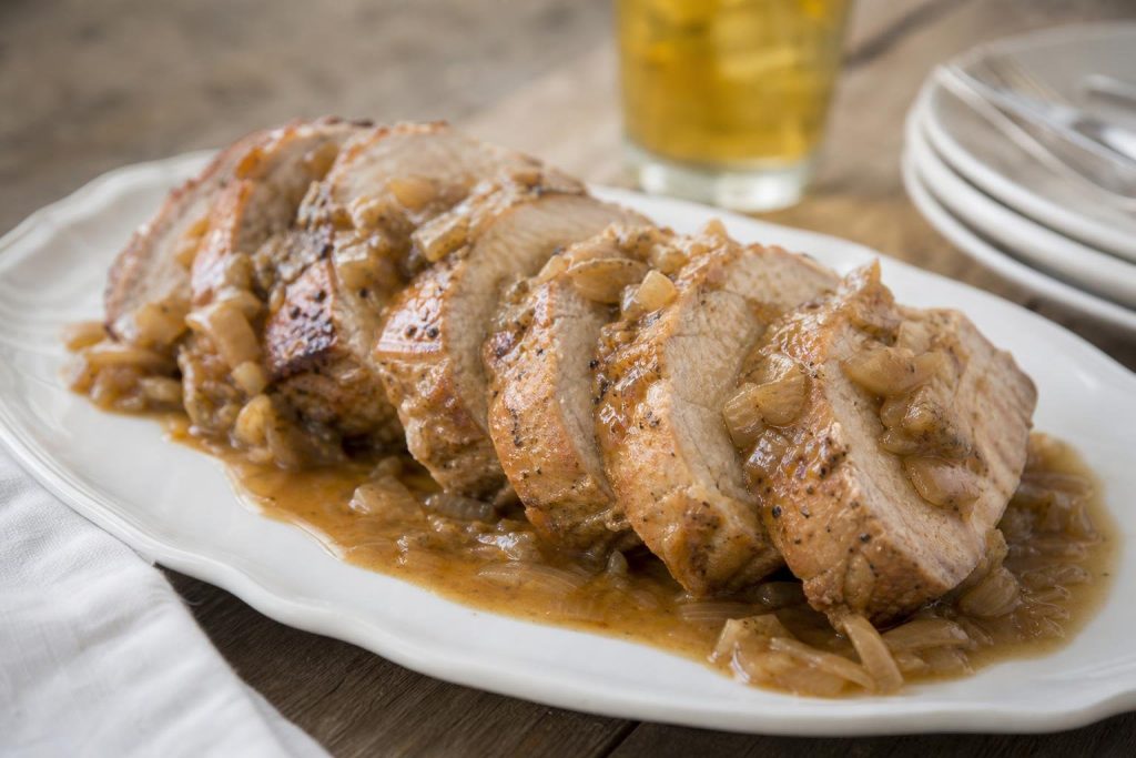 Fette di lombata di maiale alla birra con il sugo di cipolle