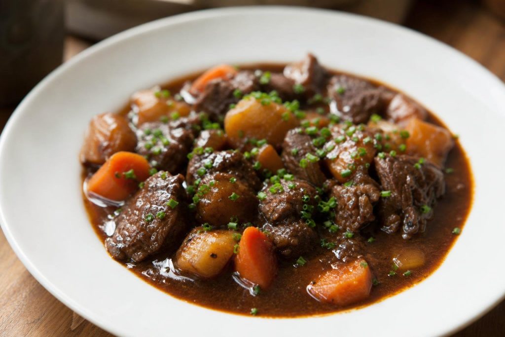 Spezzatino di vitello con birra con patate e carote nel suo sugo scuro